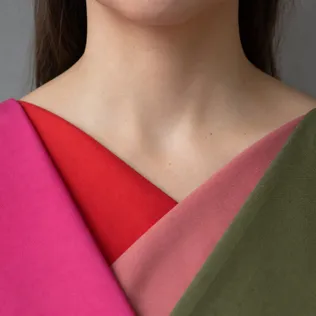 Four color-analysis drapes layered under a woman's chin: icy fuchsia, tomato red, dusty rose and olive green